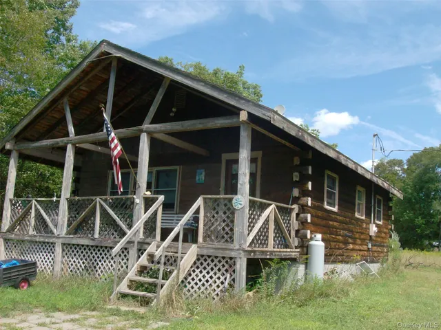 a view of a house with wooden deck front of house