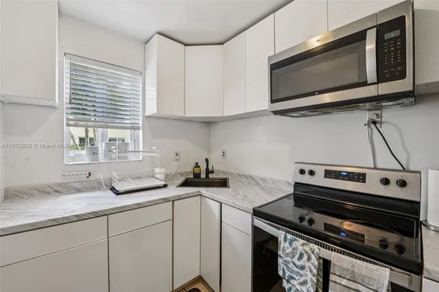 a kitchen with a sink stove and microwave