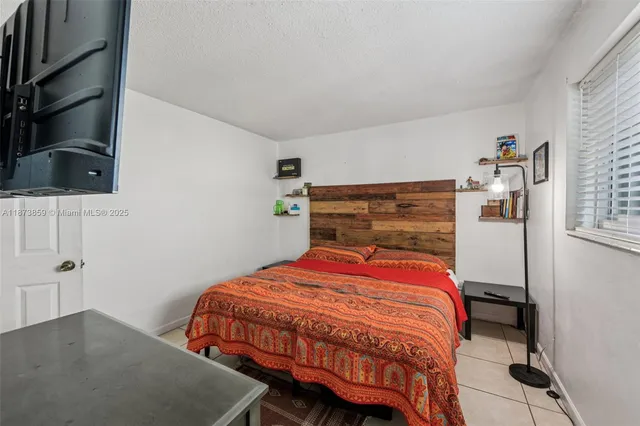 a bedroom with a bed and flat screen tv