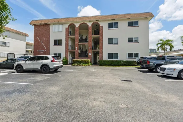 a view of a cars park in front of a building