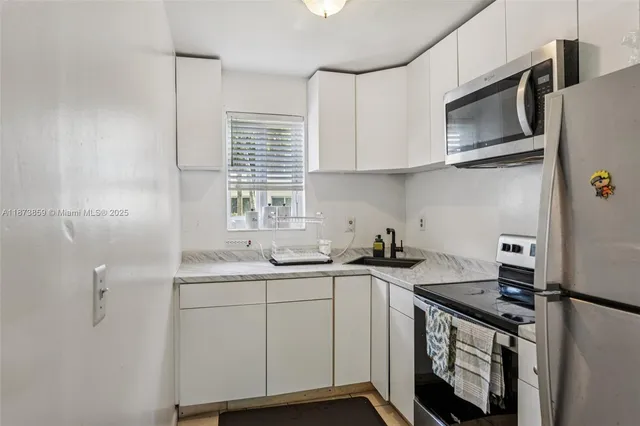 a kitchen with stainless steel appliances a sink stove and cabinets