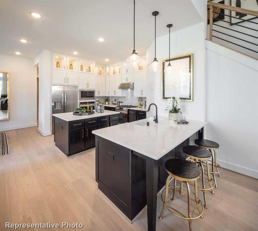 a kitchen with stainless steel appliances kitchen island granite countertop a sink a stove and chairs