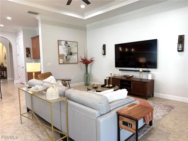 a living room with furniture kitchen view and a large window