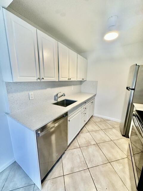 1047 Exeter C Boca Raton, FL 33434 - Photo 5 of 37 a kitchen with a sink a stove and cabinets