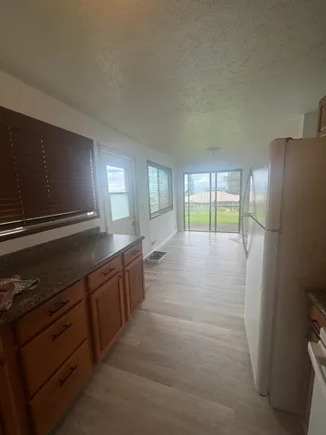 a kitchen with granite countertop a refrigerator and a sink
