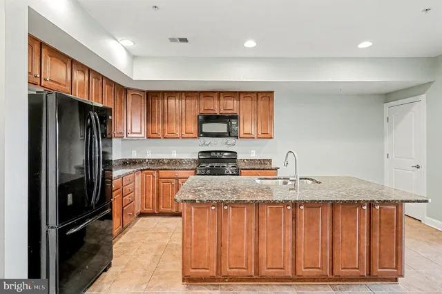 a kitchen with stainless steel appliances granite countertop a refrigerator stove and sink
