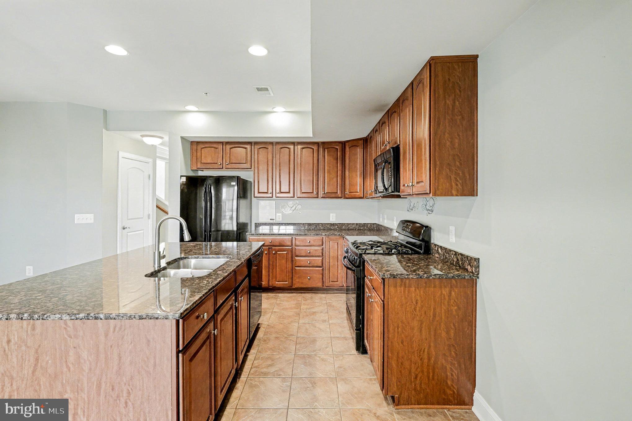 2228 Merseyside Drive Woodbridge, VA 22191 - Photo 7 of 24 a kitchen with granite countertop a sink a stove and cabinets