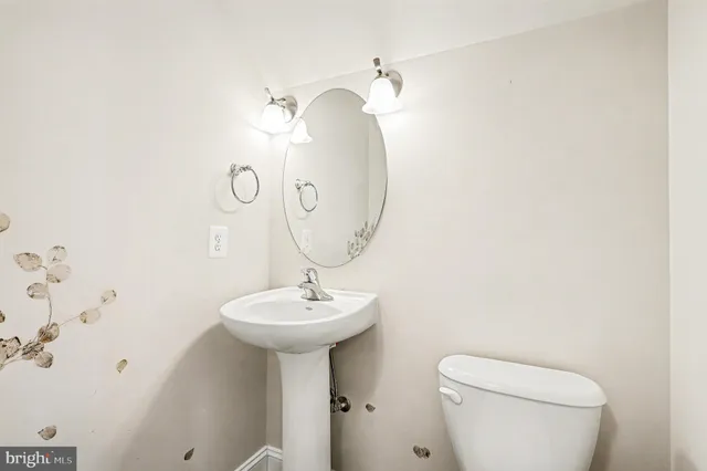 a bathroom with a sink toilet and mirror