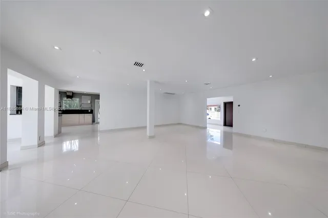a view of a livingroom with an empty space and a refrigerator