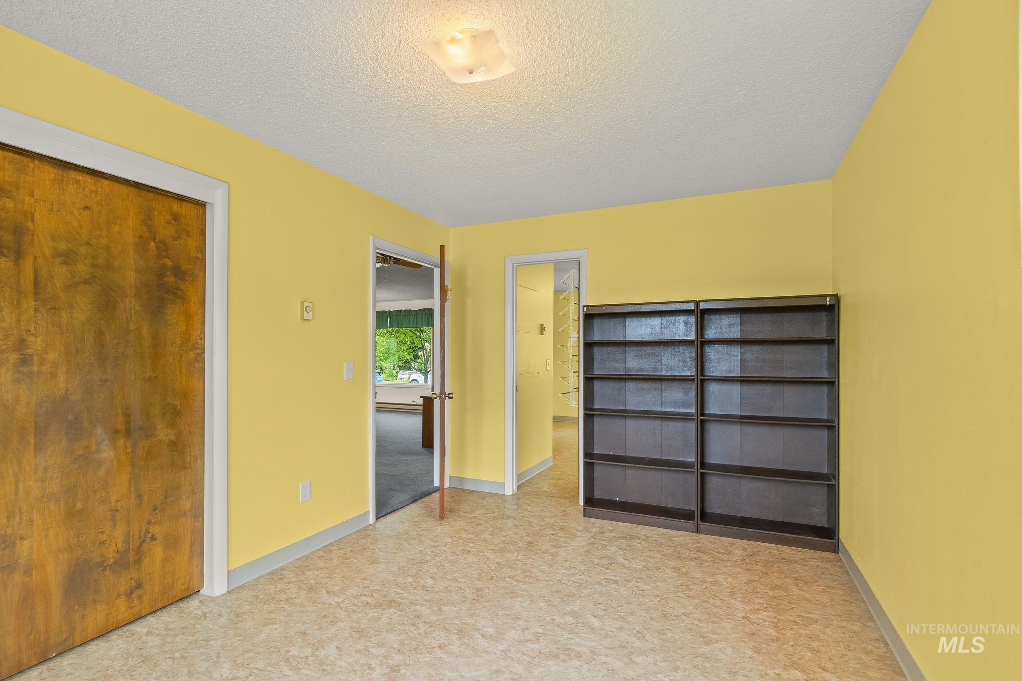 1721 3rd Street Lewiston, ID 83501 - Photo 38 of 45 Interior room featuring warm yellow walls, a built-in shelving unit, and patterned vinyl flooring