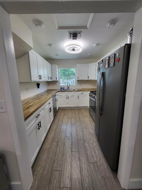 995 Emerald Drive Mount Dora, FL 32757 - Photo 28 of 33 a kitchen with a refrigerator a sink and dishwasher a refrigerator with wooden floor