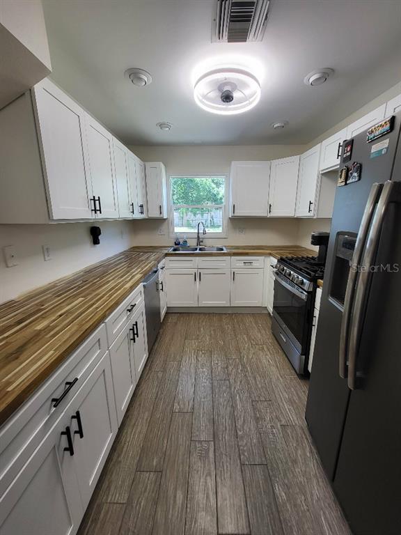 995 Emerald Drive Mount Dora, FL 32757 - Photo 29 of 33 a kitchen with granite countertop wooden floors appliances and cabinets