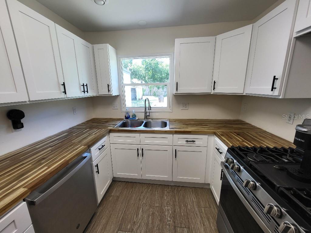 995 Emerald Drive Mount Dora, FL 32757 - Photo 31 of 33 a kitchen with granite countertop a stove sink and cabinets