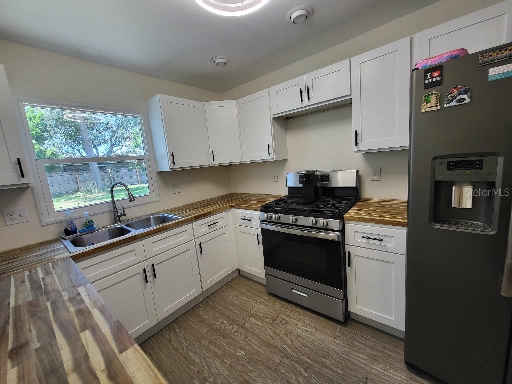 995 Emerald Drive Mount Dora, FL 32757 - Photo 32 of 33 a kitchen with stainless steel appliances granite countertop a stove a sink and a refrigerator