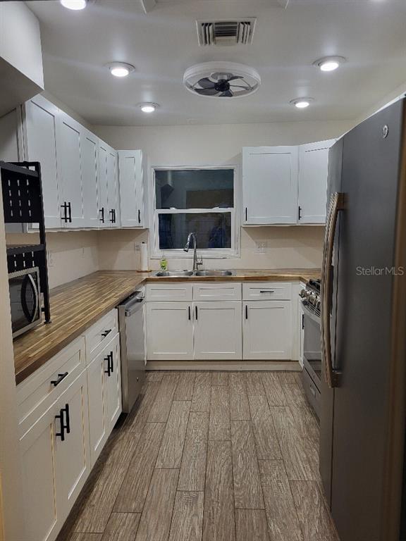 995 Emerald Drive Mount Dora, FL 32757 - Photo 33 of 49 a kitchen with a sink stainless steel appliances and cabinets