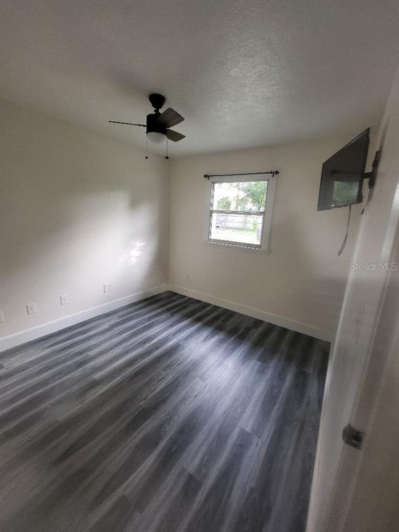 995 Emerald Drive Mount Dora, FL 32757 - Photo 39 of 49 an empty room with wooden floor fan and windows