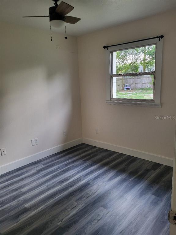 995 Emerald Drive Mount Dora, FL 32757 - Photo 40 of 49 a view of an empty room with wooden floor and a window