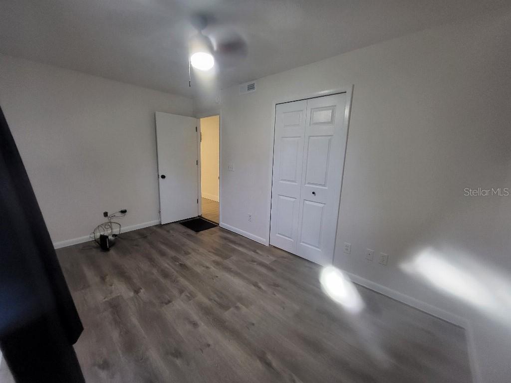 995 Emerald Drive Mount Dora, FL 32757 - Photo 46 of 49 an empty room with wooden floor and windows