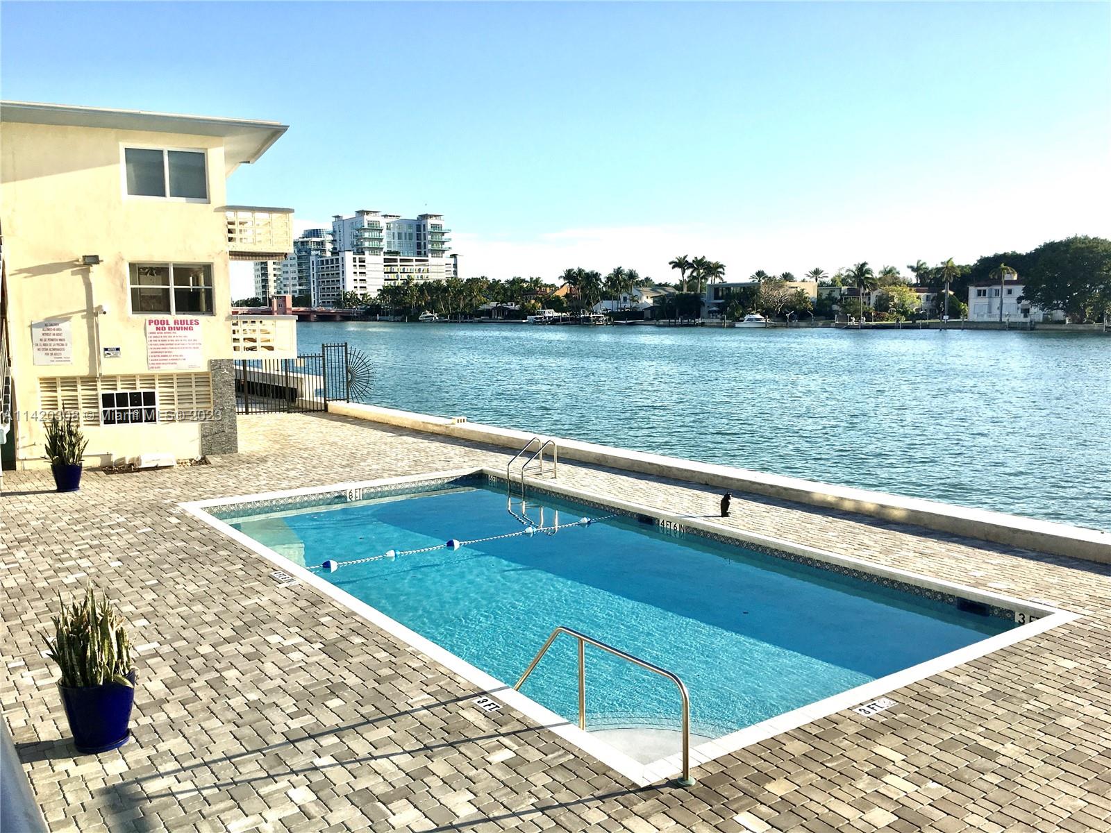 a view of swimming pool with outdoor seating and lake view