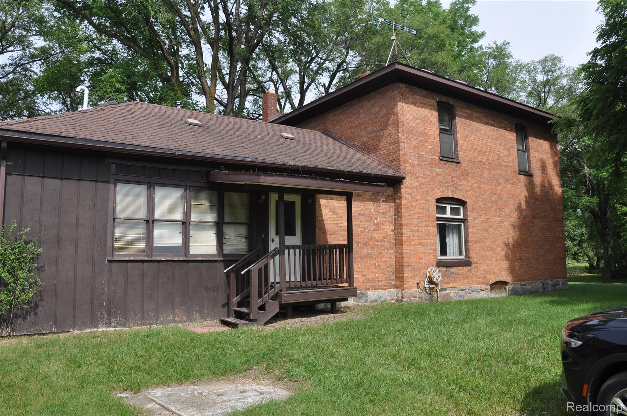 3954 Mayville Road Silverwood, MI 48760 - Photo 4 of 30 Brick and wood-sided exterior featuring a covered porch, multiple windows, and a shingled roof