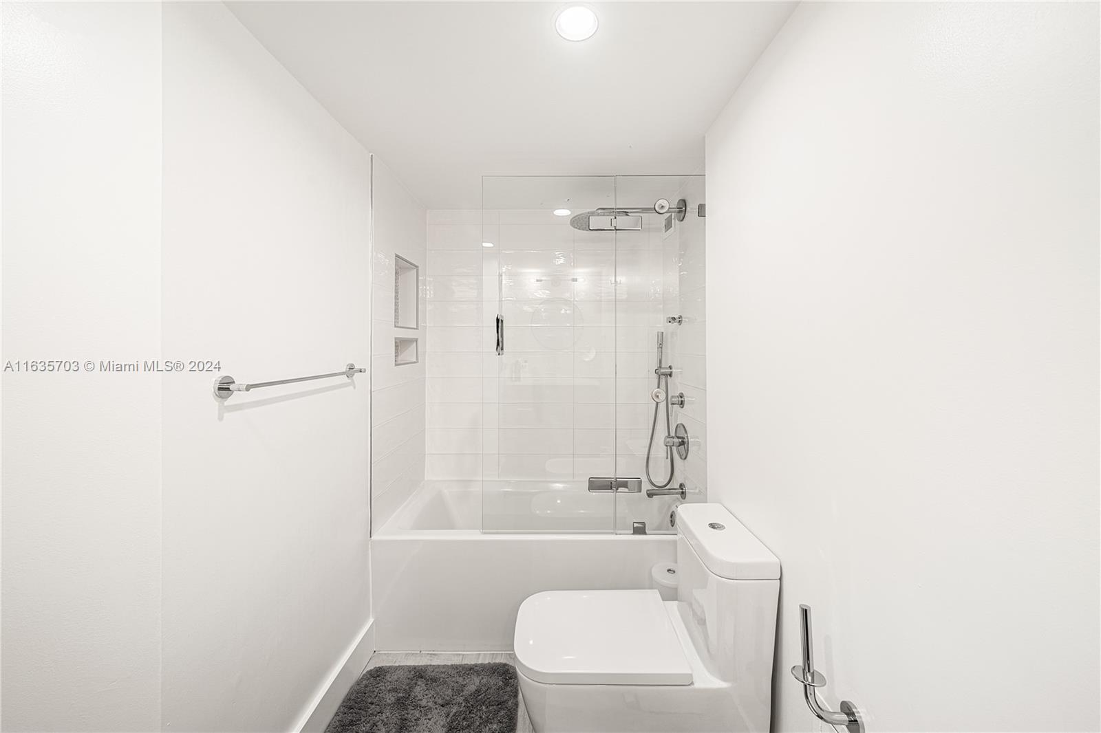 5600 Condominium Miami Beach, FL 33140 - Photo 22 of 27 a bathroom with a shower a toilet and a sink