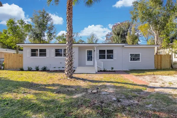 a view of a house with backyard and trees