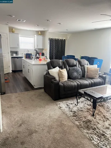 a living room with furniture kitchen view and a couch