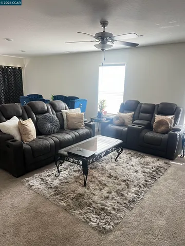 a living room with furniture a rug and a window
