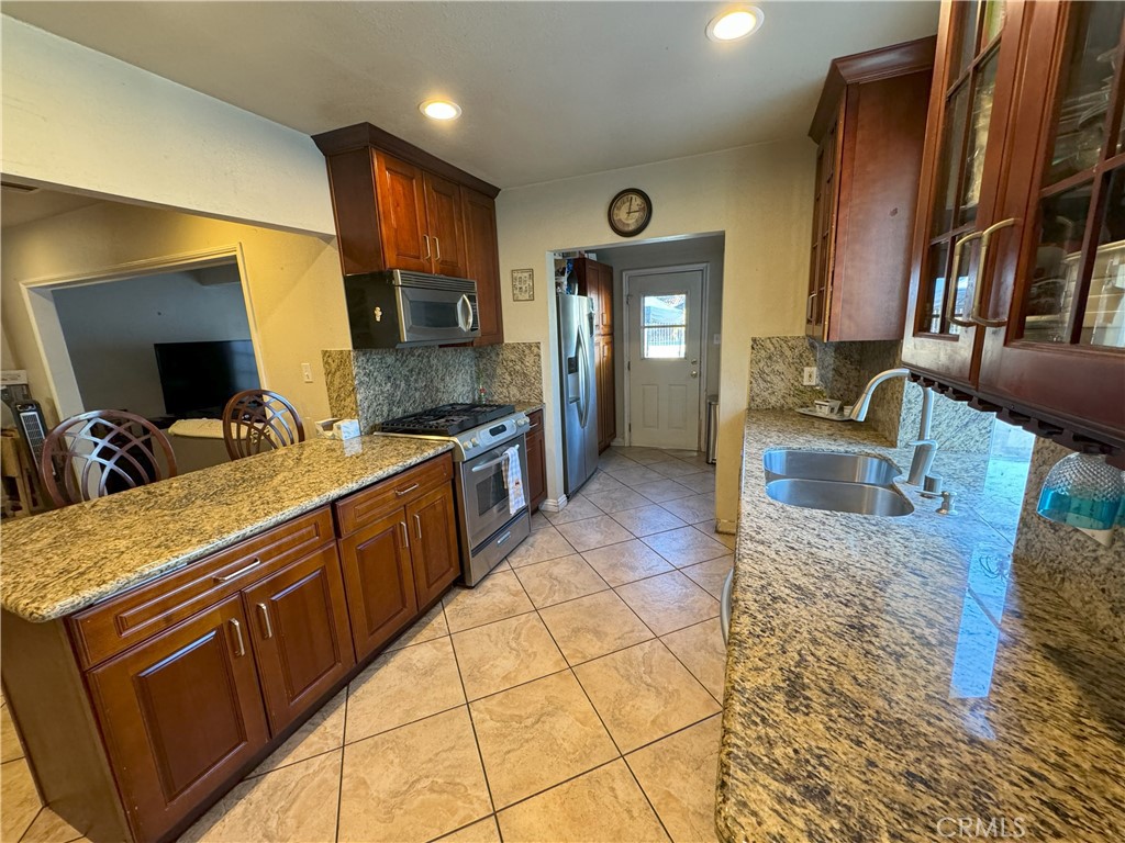 8429 Sheffield Road San Gabriel, CA 91775 - Photo 7 of 19 a kitchen with stainless steel appliances granite countertop a sink stove and refrigerator
