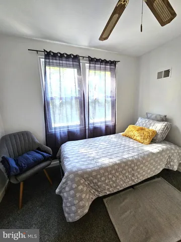 a bedroom with a bed chair and window