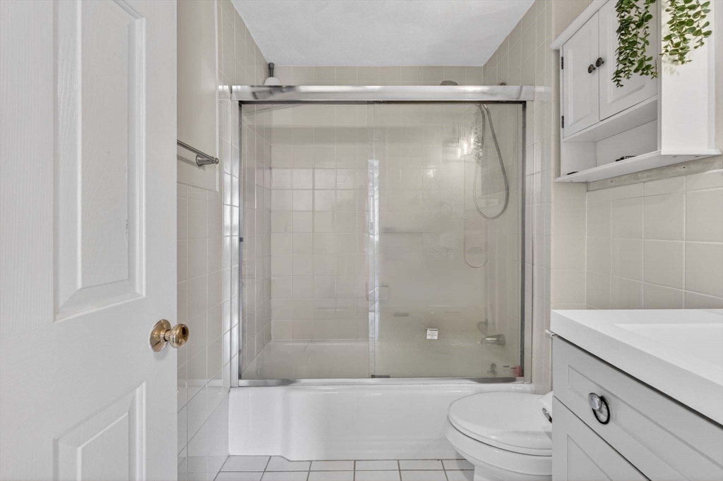 588 Main Street, Unit 3D Stoneham, MA 02180 - Photo 14 of 22 a bathroom with a granite countertop bathtub shower sink vanity and toilet