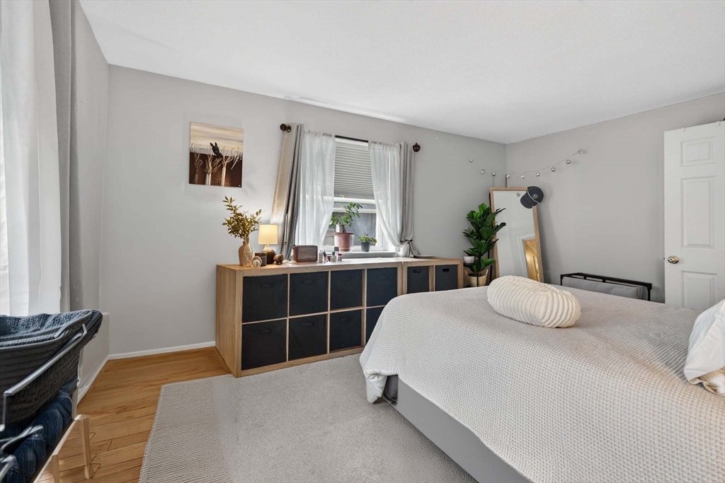 588 Main Street, Unit 3D Stoneham, MA 02180 - Photo 16 of 22 a bedroom with a bed and dresser with mirror