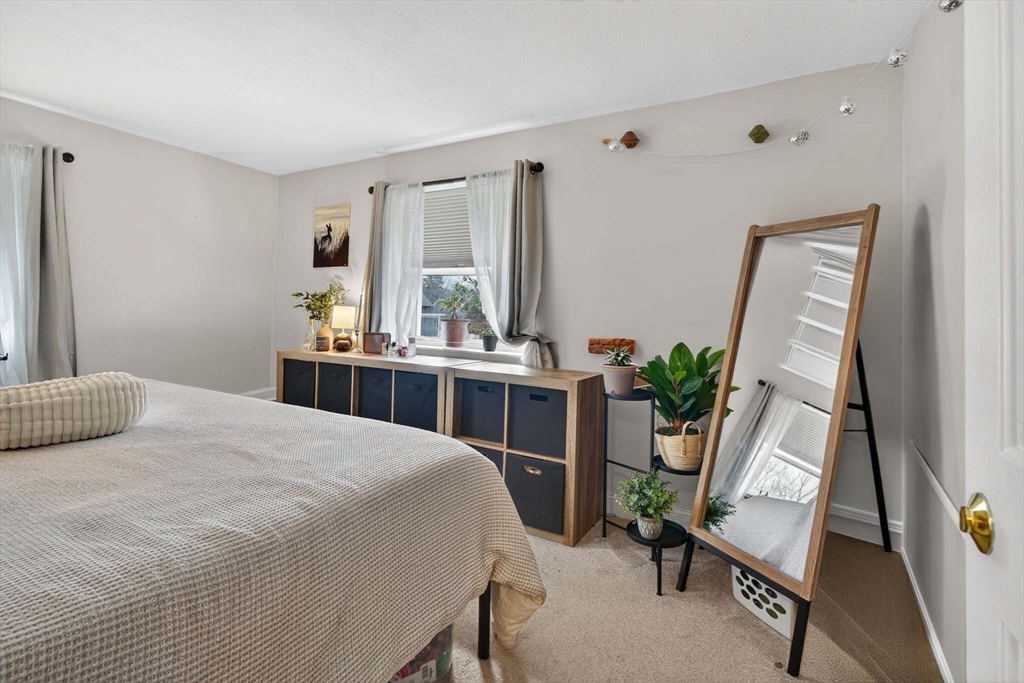 588 Main Street, Unit 3D Stoneham, MA 02180 - Photo 18 of 22 a bedroom with a bed table chair and a window