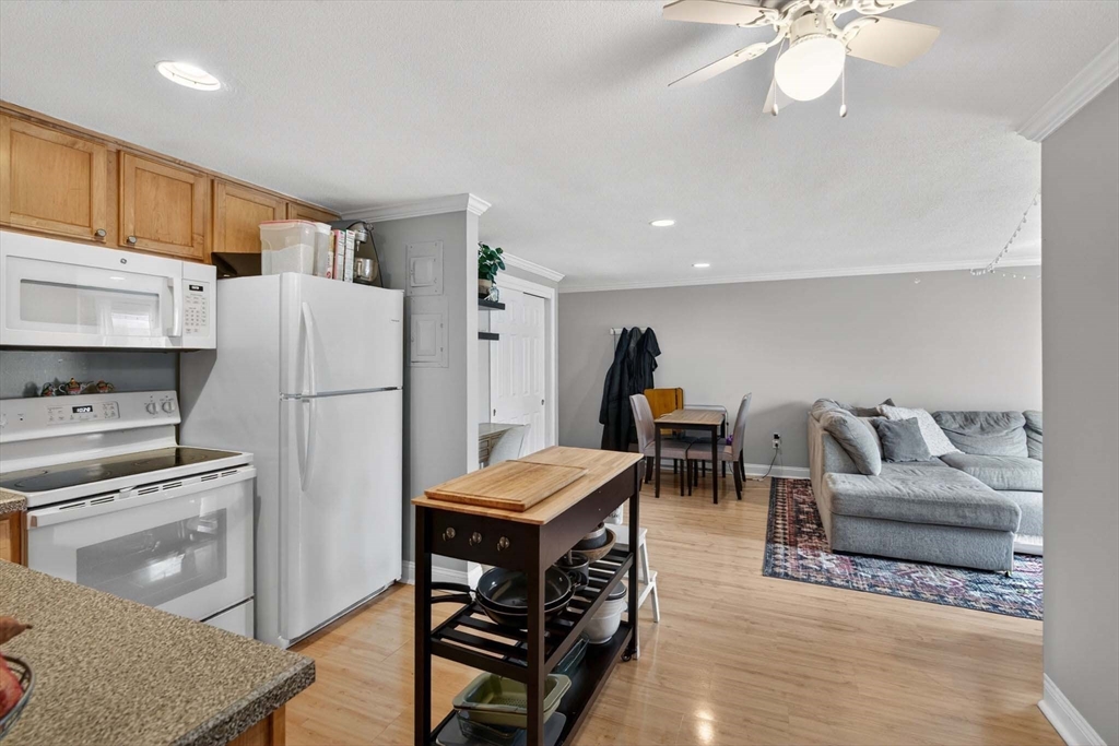 588 Main Street, Unit 3D Stoneham, MA 02180 - Photo 5 of 22 a living room with furniture a flat screen tv and kitchen view