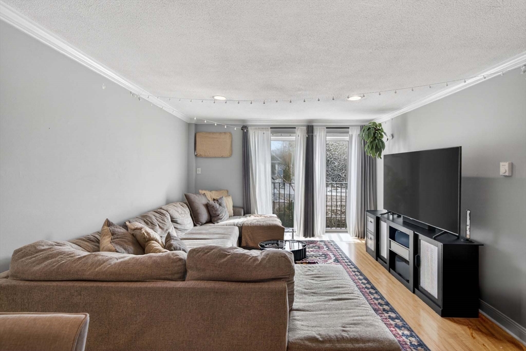 588 Main Street, Unit 3D Stoneham, MA 02180 - Photo 7 of 22 a living room with furniture and a flat screen tv
