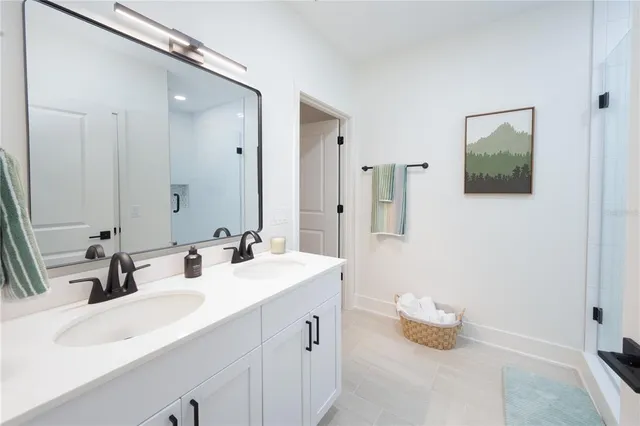 a bathroom with a double vanity sink a mirror and a