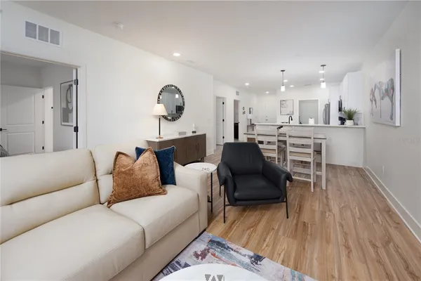 a living room with furniture and a wooden floor