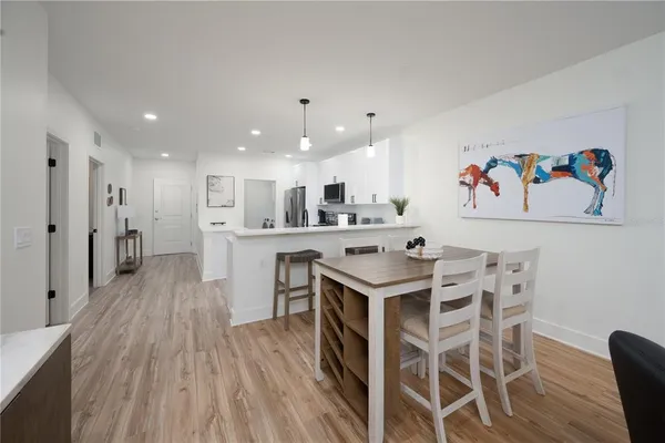 a kitchen with a table chairs refrigerator and microwave
