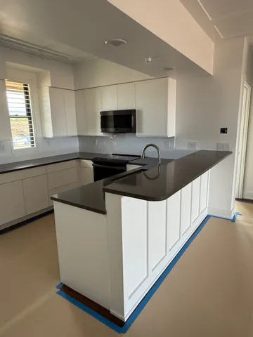 a kitchen with granite countertop a sink and a stove top oven