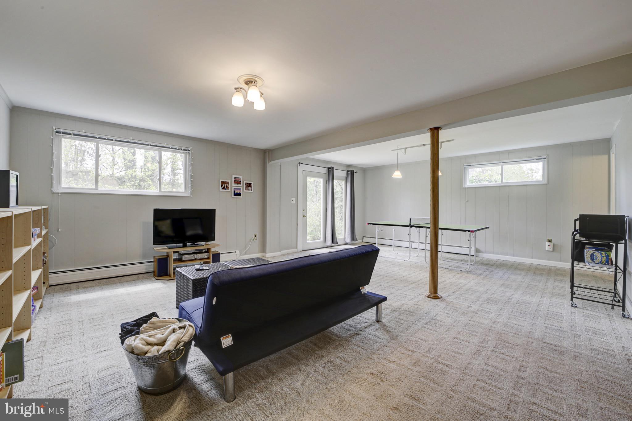 6326 Rockhurst Road Bethesda, MD 20817 - Photo 23 of 32 a living room with furniture a window and a flat screen tv
