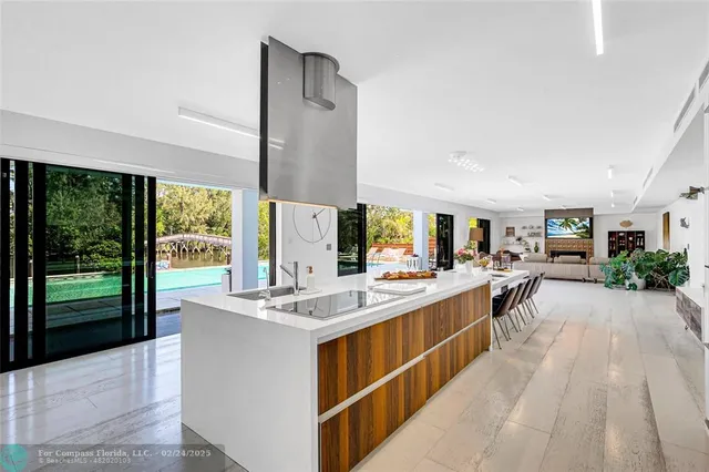 a large kitchen with kitchen island a large window in it