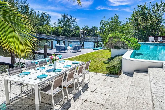 a view of a patio with table and chairs potted plants with wooden floor and fence
