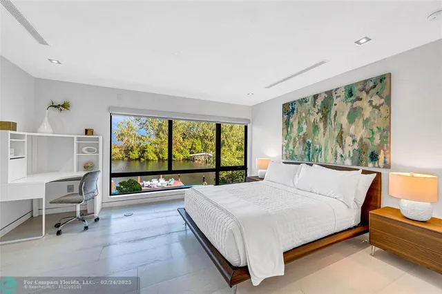 a bedroom with a bed and a large window