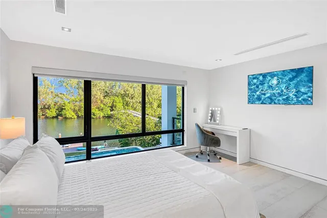 a bedroom with a bed and large windows