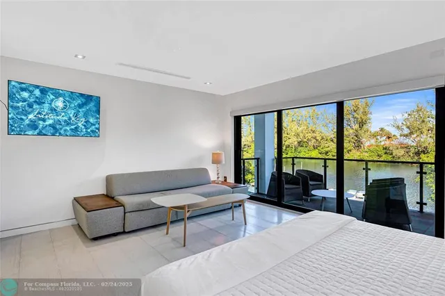 a living room with furniture large windows and a flat screen tv