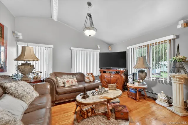 a living room with furniture a flat screen tv and a large window
