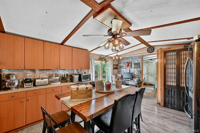 a dining room with stainless steel appliances a table and chairs