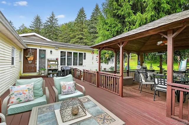 a view of a patio with couches chairs and wooden floor