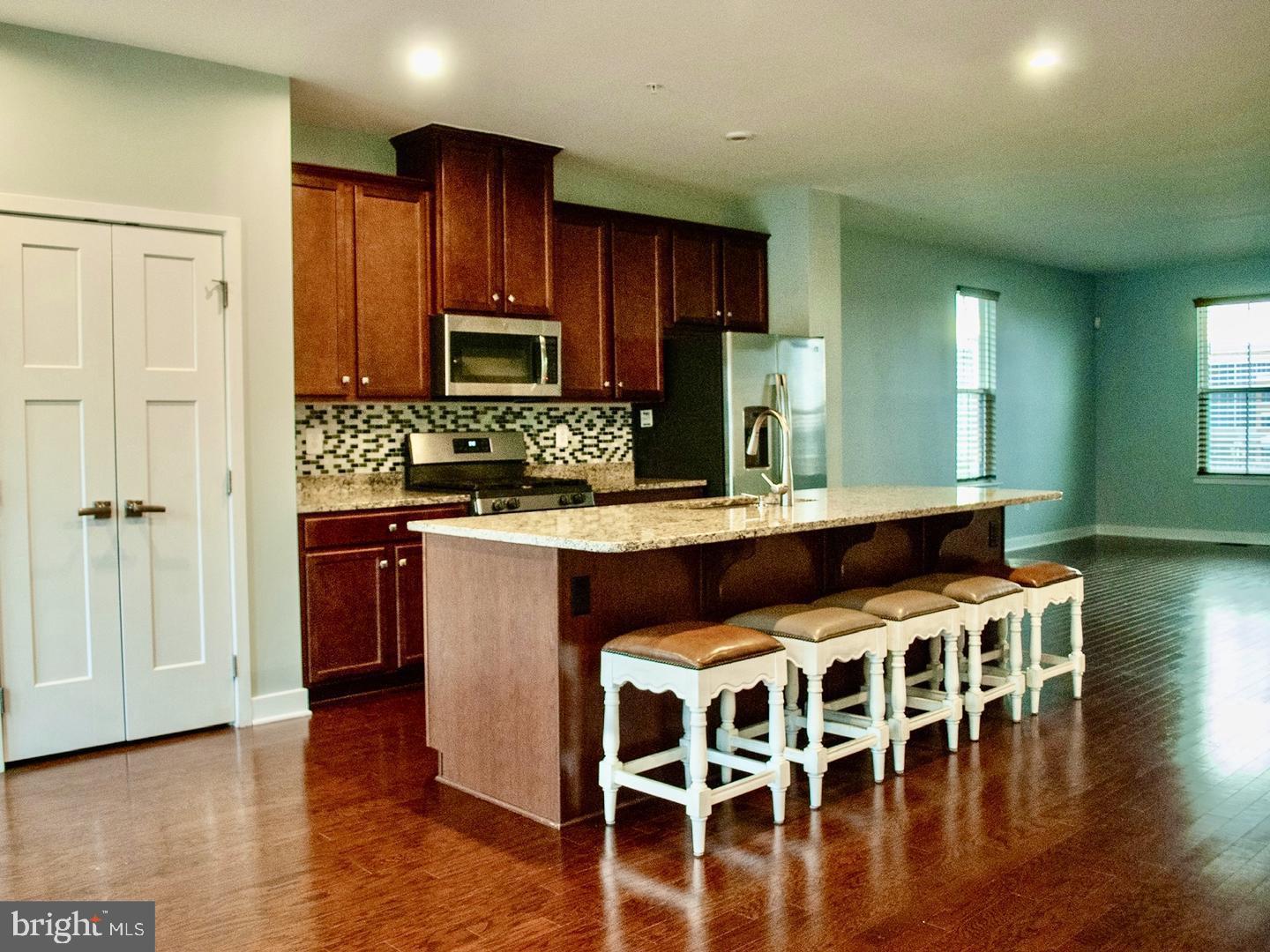 601 Colindale Street Middle River, MD 21220 - Photo 2 of 17 a kitchen with a wooden floor and chairs