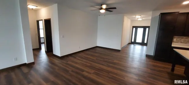 a view of a hallway with wooden floor and a bathroom
